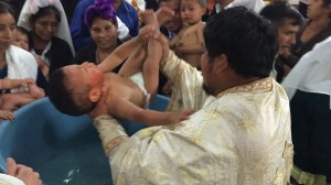 Archimandrite Evangelos baptizes one of the many infants in Aguacate.